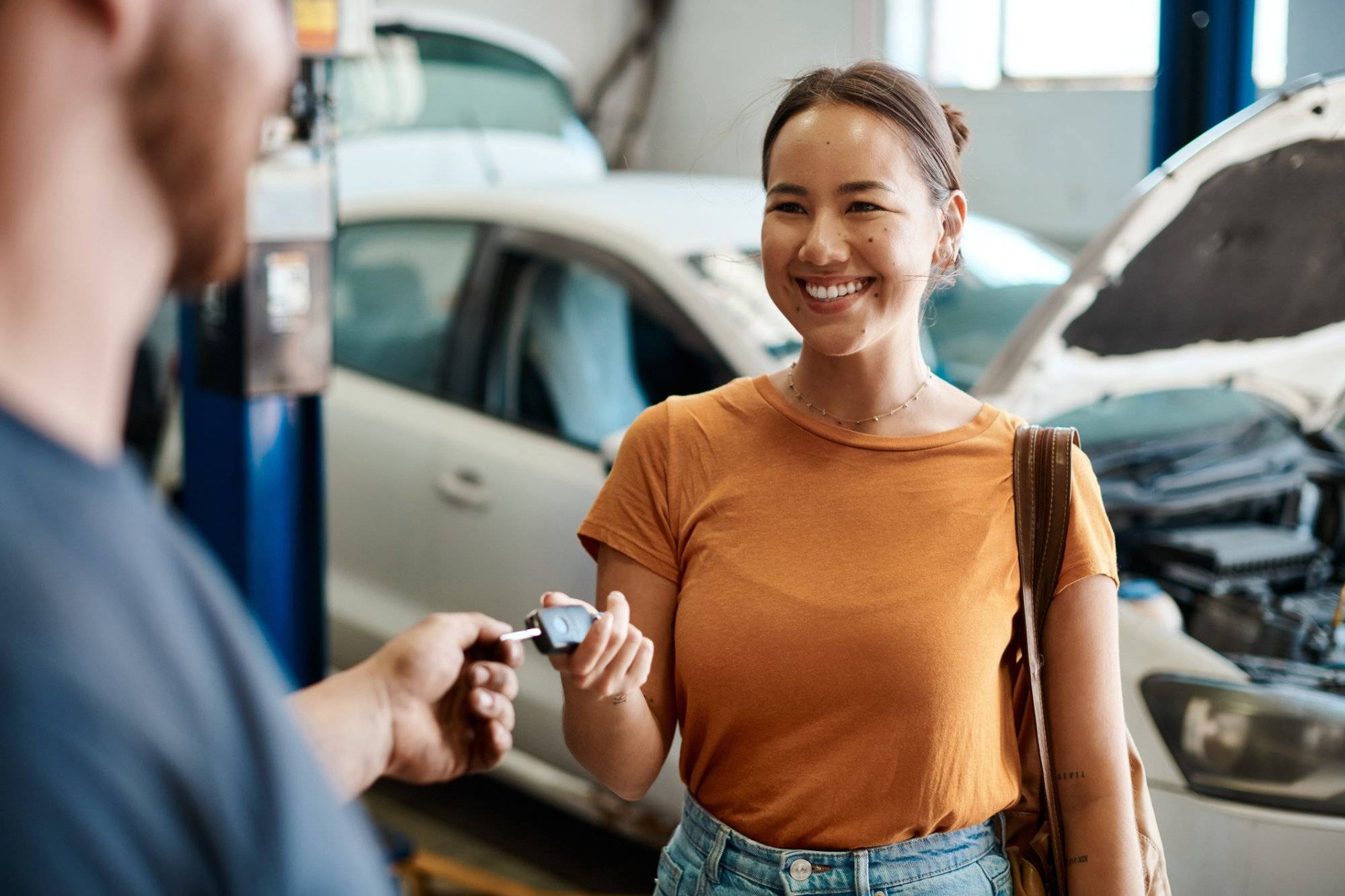 Shot of a woman receiving her car keys Shot of a woman receiving her car keys