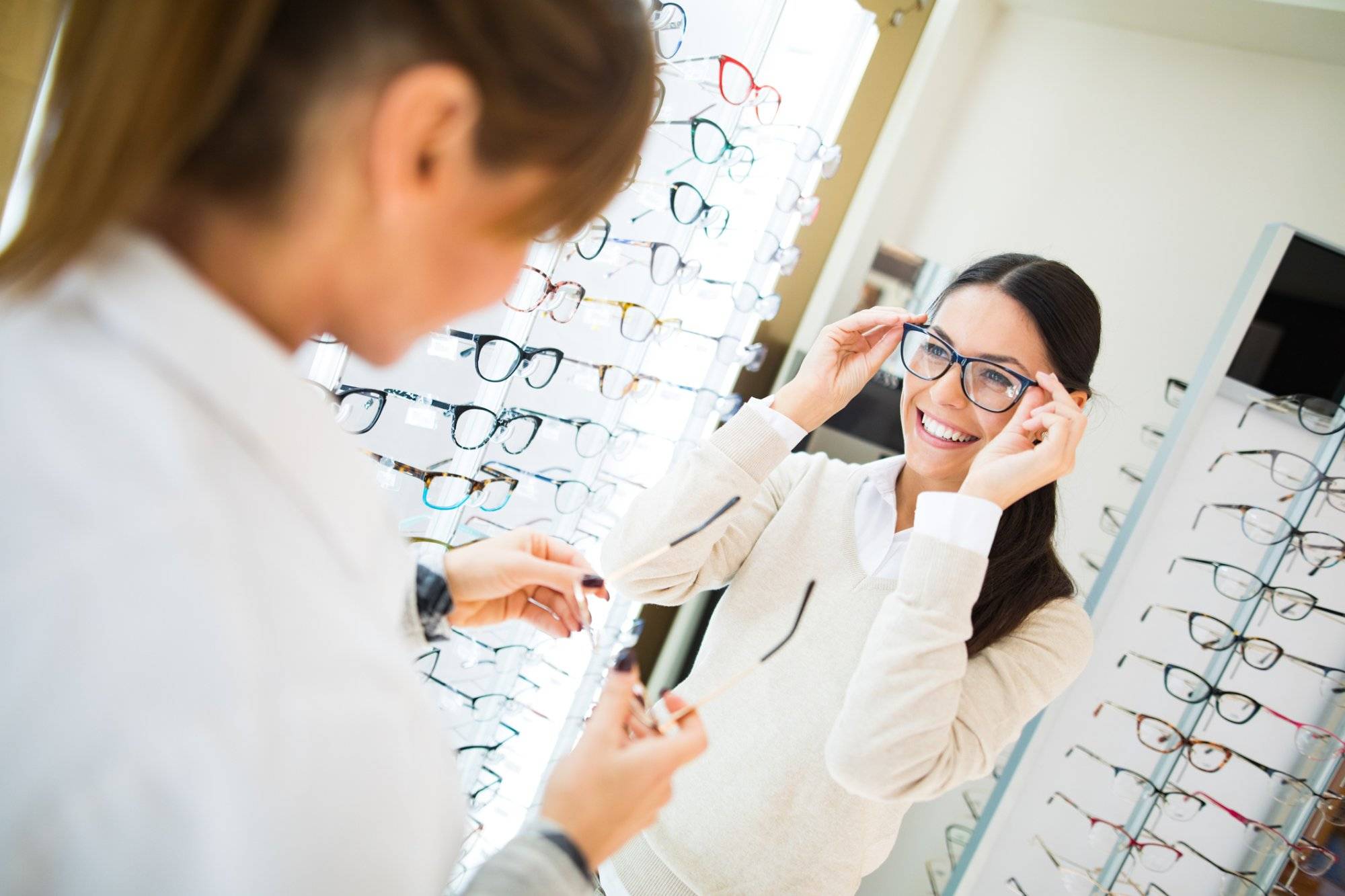 Woman trying on eyeglasses in optical shop